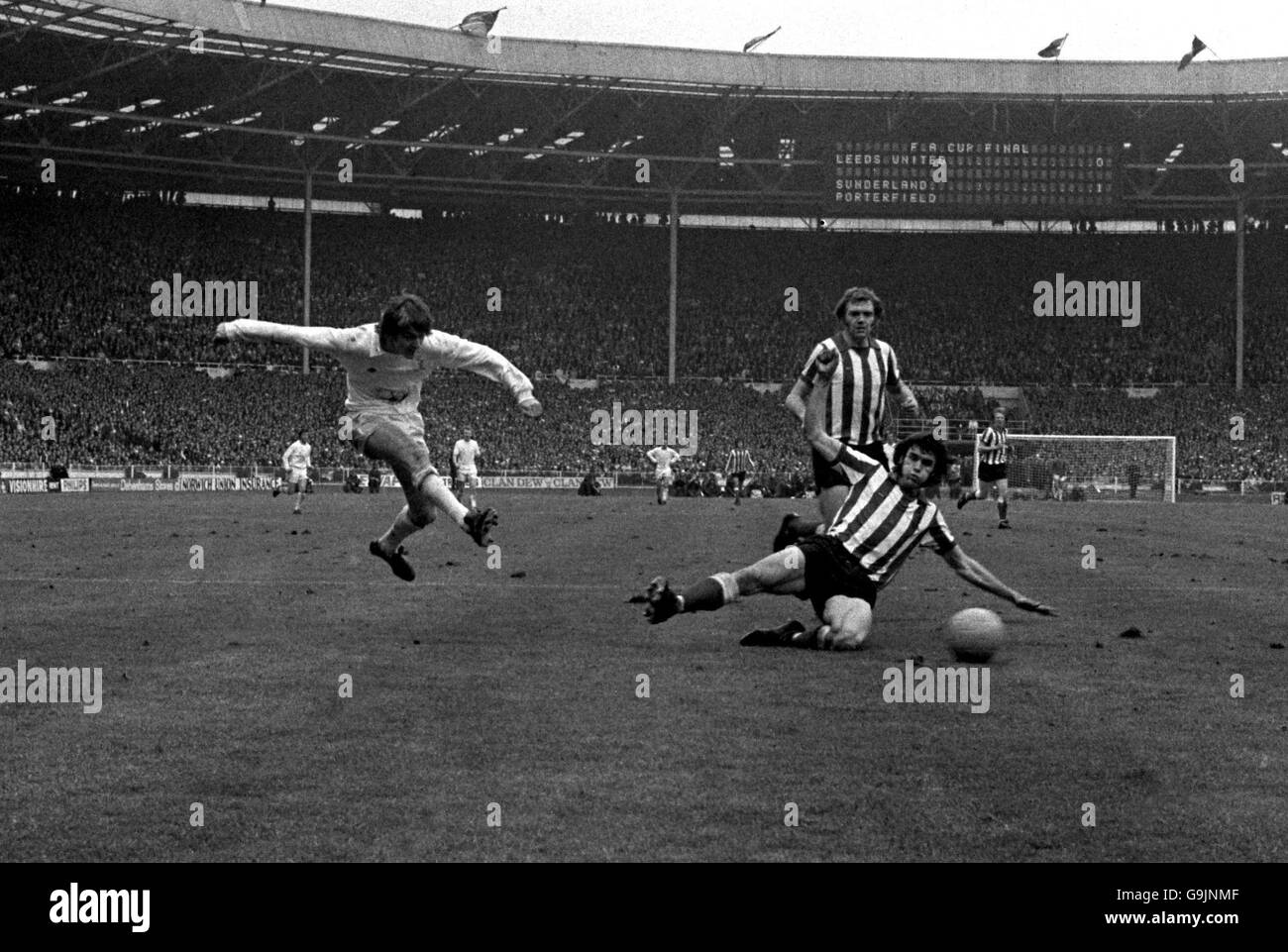 Allan Clarke di Leeds United (l) spara un colpo oltre Sunderland's. Dave Watson (r) Foto Stock