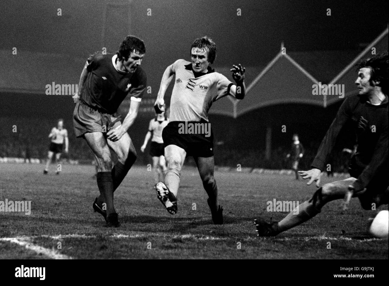 John Toshack di Liverpool (l) spara la palla oltre Wolverhampton Wanderers' Derek Parkin (c) a segnare il secondo gol della sua squadra La vittoria del 3-1 che ha segnato il campionato di campionato e ha sigillato Relegazione dei lupi Foto Stock