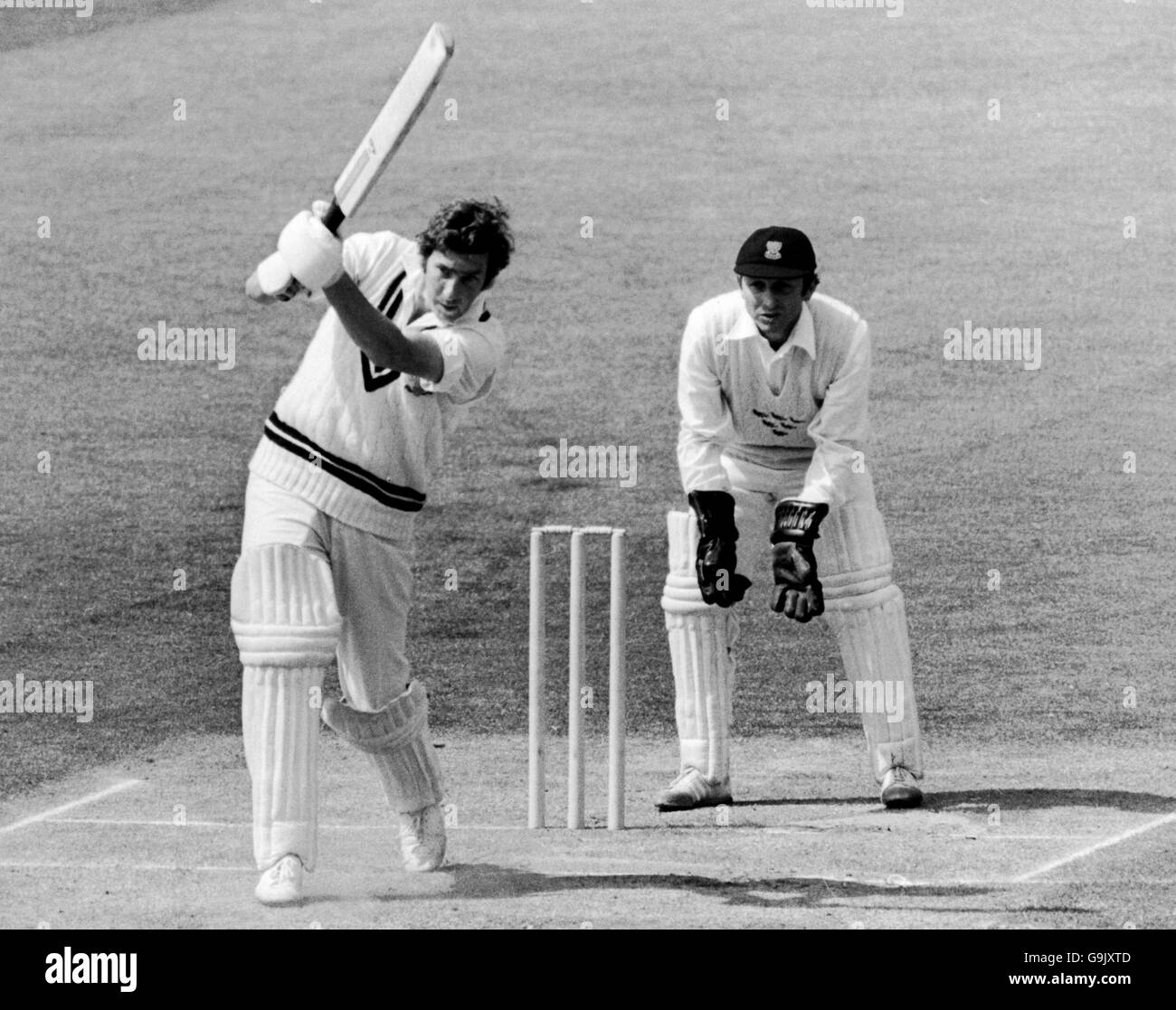 Roger Knight di Surrey (l) riporta la palla oltre il bowler, guardato dal wicketkeeper di Sussex Arnold Long (r) Foto Stock