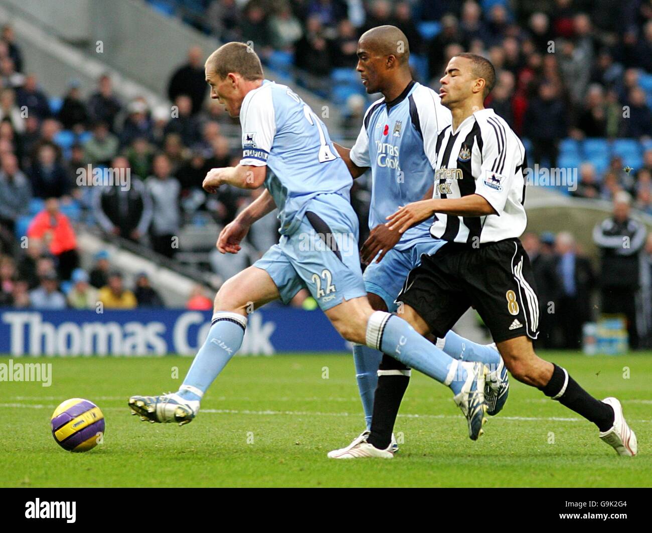Kieron Dyer, Newcastle United (l) si esaurisce dopo un lungo periodo di stay-off, viene espropriata da Richard Dunne (l) di Manchester City, come Sylvain Distin guarda sopra Foto Stock