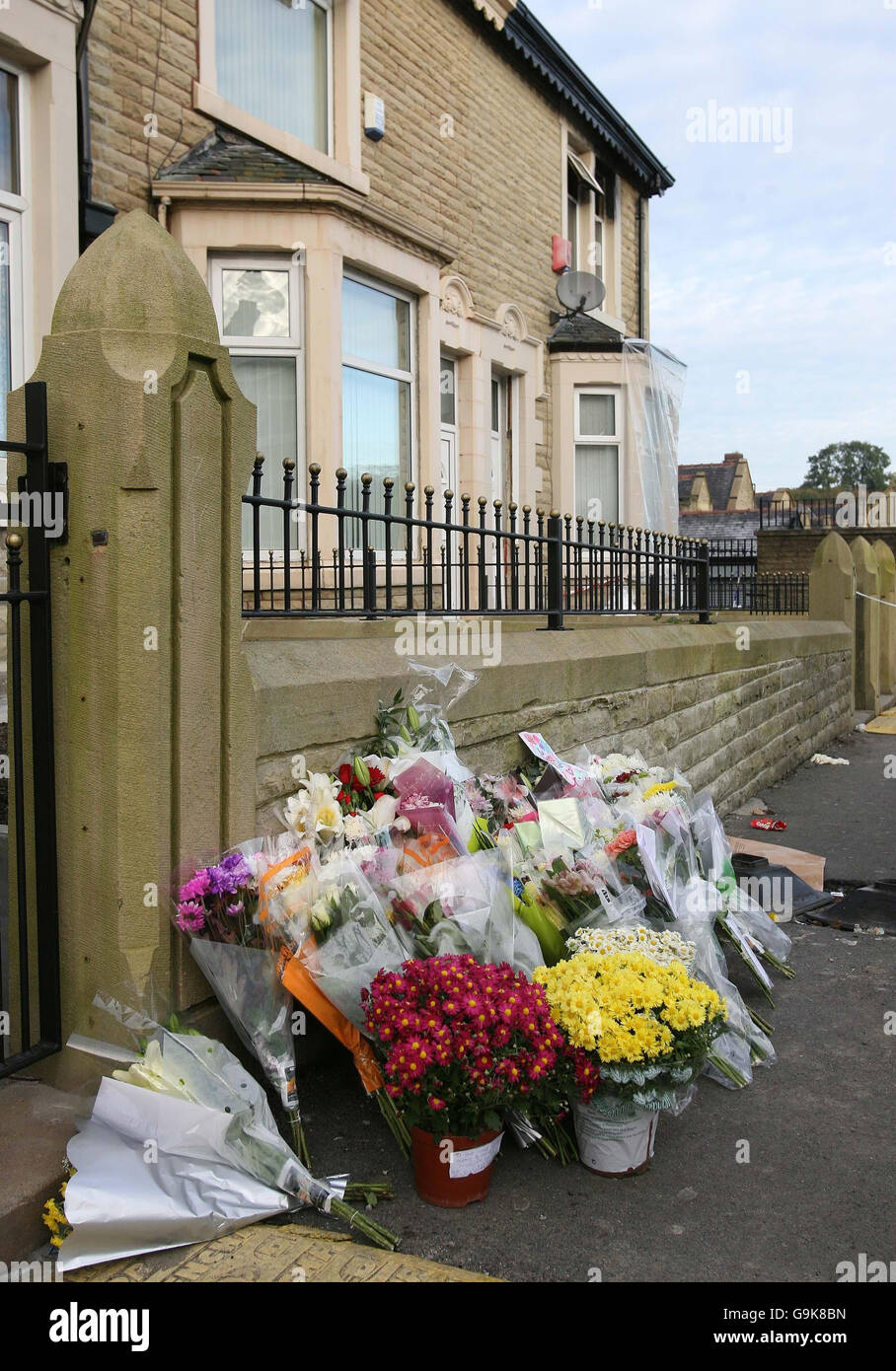 I fiori si trovano fuori dalla casa di Tremellen Street, dove i detective continuano le indagini sull'omicidio di una madre e delle sue quattro figlie in un incendio nella loro casa di Accrington. Foto Stock