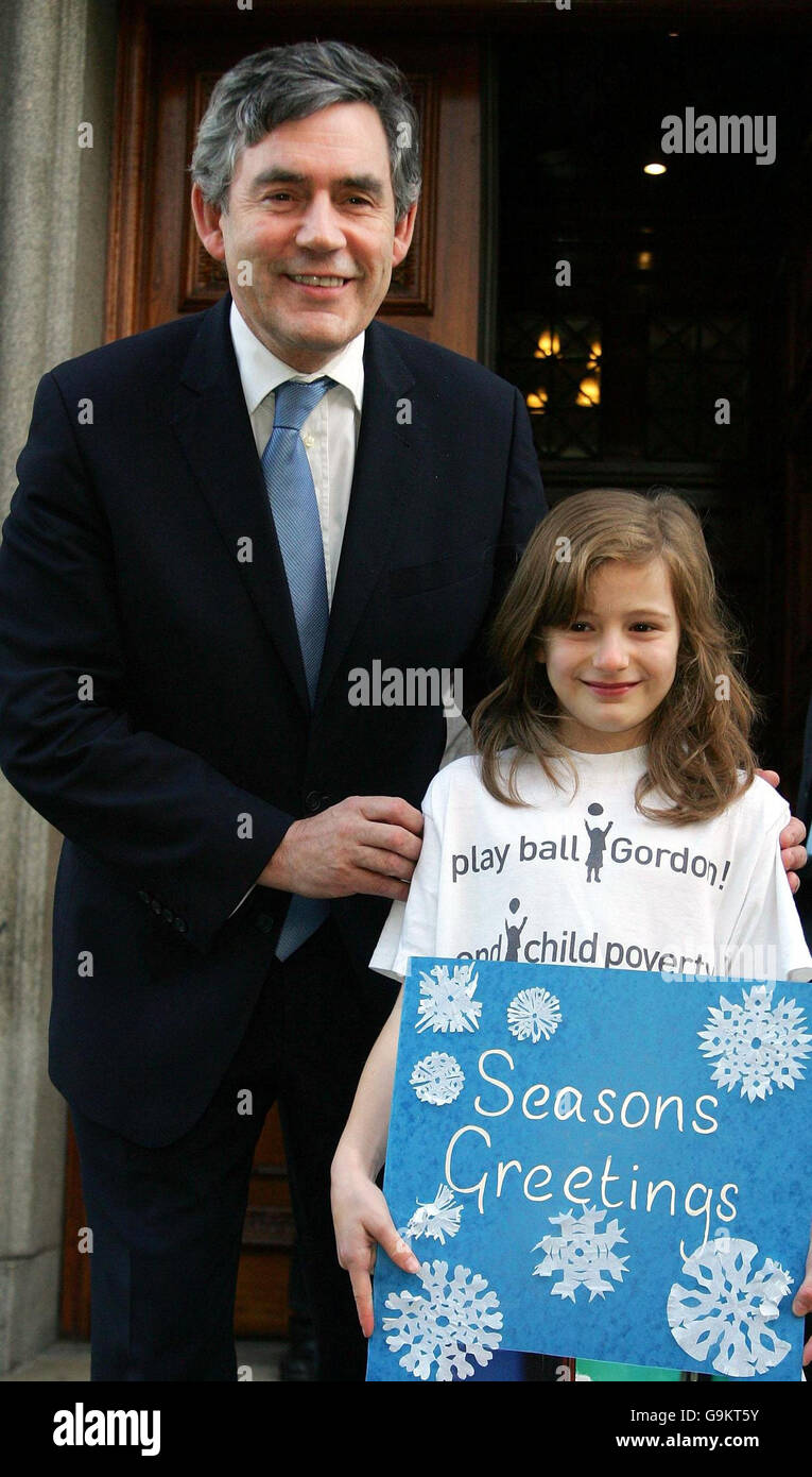 Il Cancelliere Gordon Brown è in piedi con Kirby, uno dei cinque figli della Victory School di Elephant and Castle, a sud di Londra, che ha consegnato le cartoline di auguri Seasons al signor Brown sulle scale del Tesoro per il giorno universale dei bambini. Foto Stock