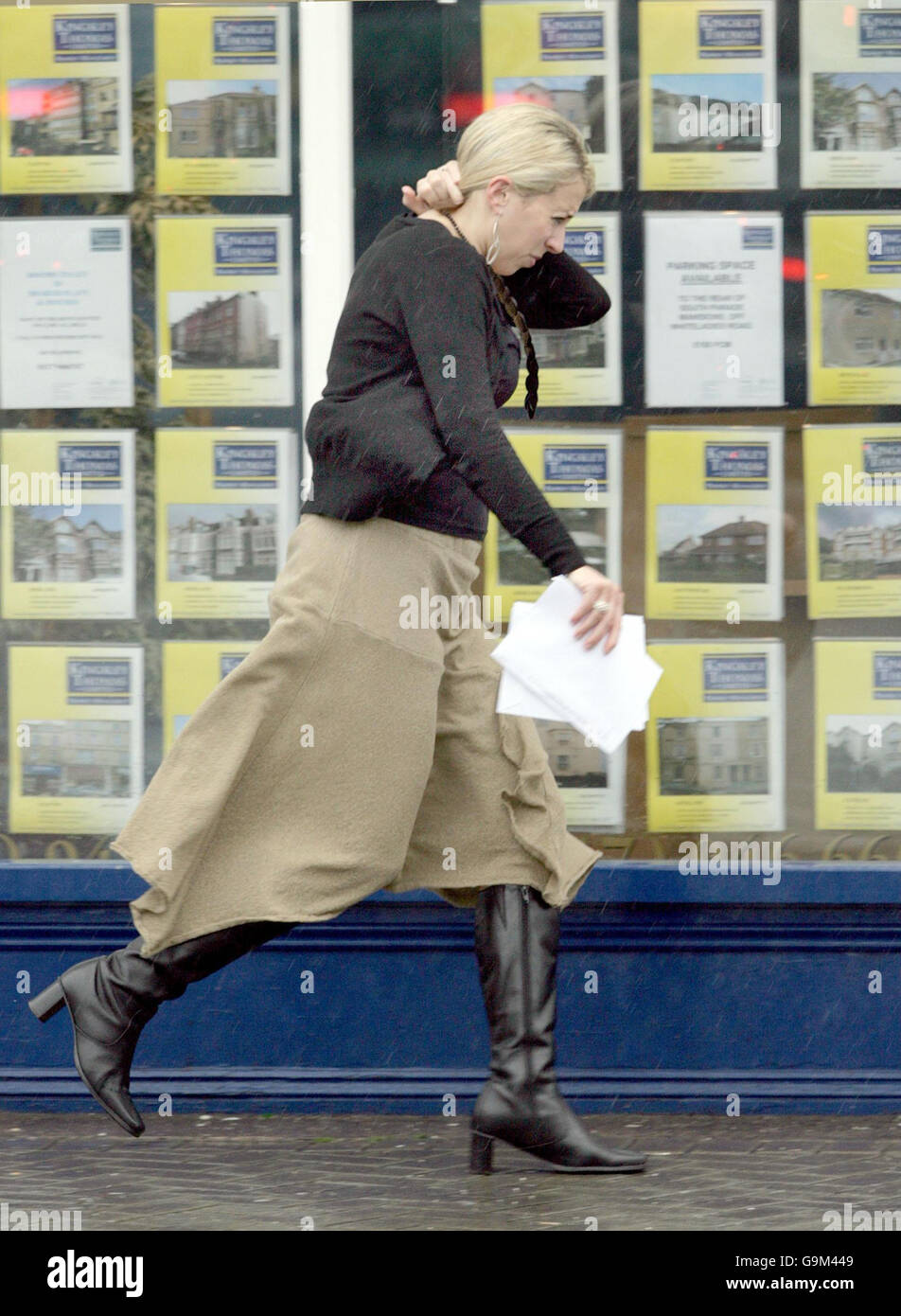 Una donna corre lungo Whiteladies Road mentre la pioggia pesante colpisce Bristol. Foto Stock