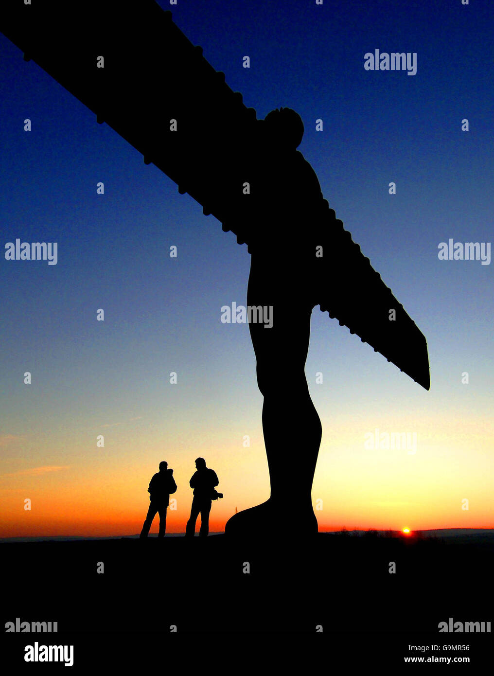 Il sole tramonta dietro la statua dell'Angelo del Nord di Antony Gormley a Gateshead. Foto Stock