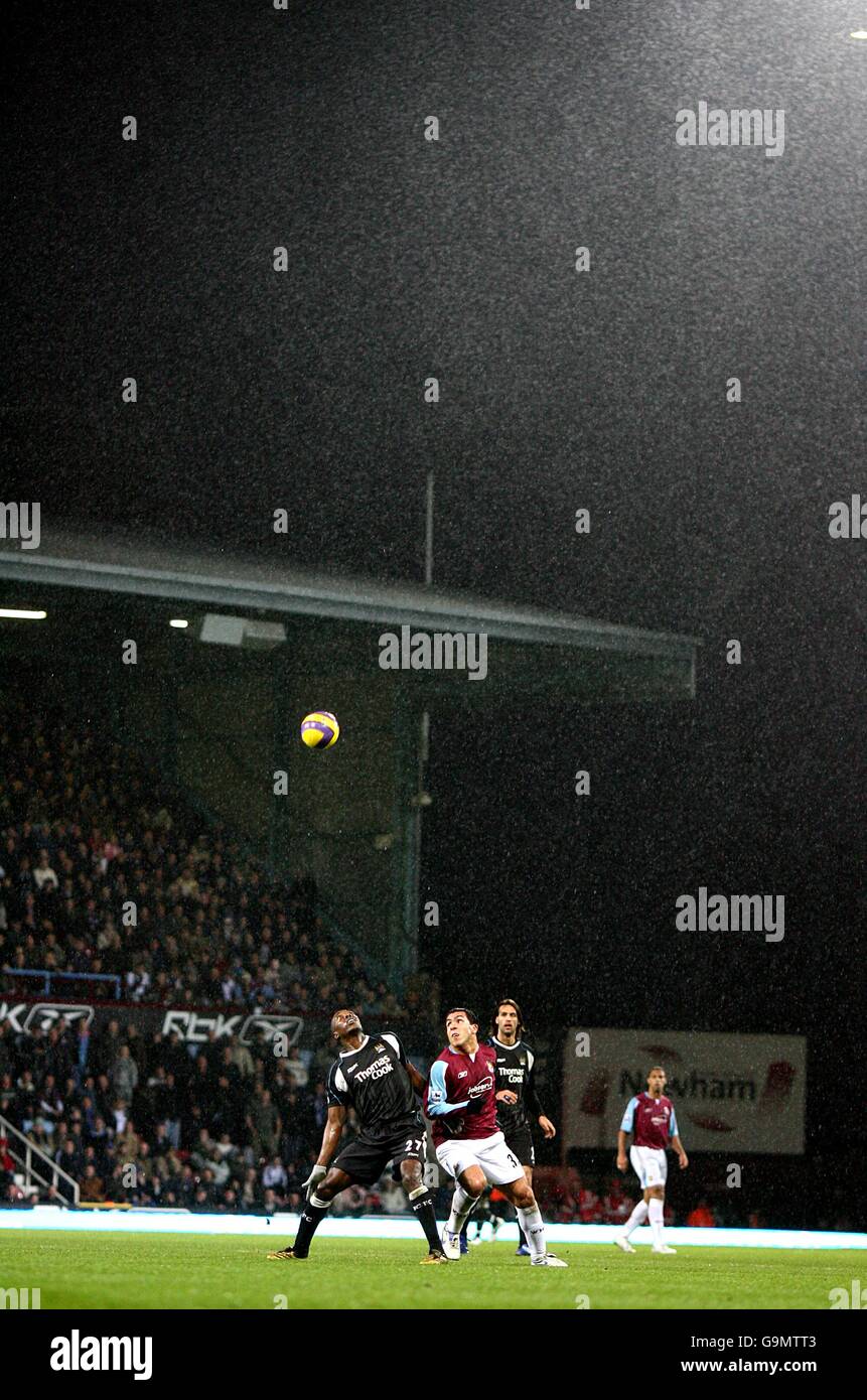 Hatem Tradelsi (l) di Manchester City e Carlos di West Ham United Tevez battaglia per la palla sotto la pioggia a Upton Parcheggio Foto Stock