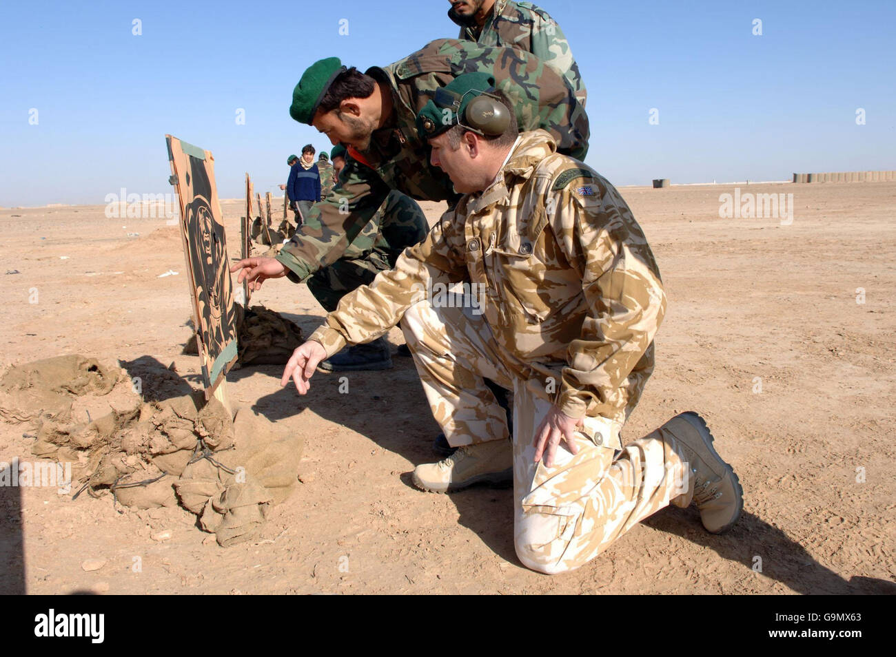 SGT 'H' Higgins di Londra discute i risultati di una pratica di tiro dei soldati dell'esercito nazionale dell'Afghanistan su una gamma vicino al Bastione del campo in Afghanistan. Foto Stock