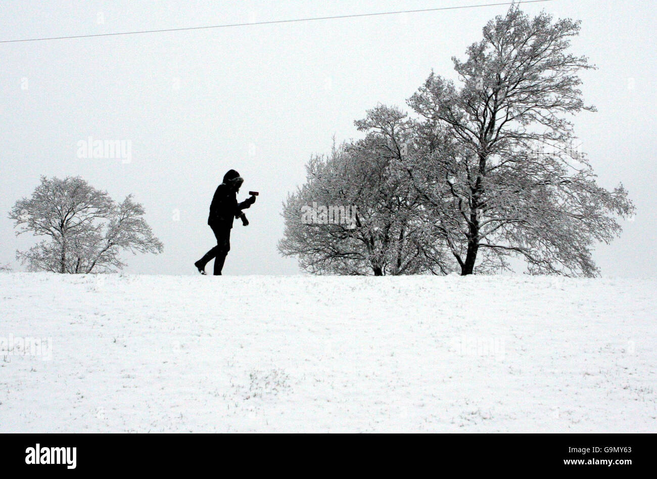 Una persona cammina attraverso la neve vicino a Denny, Scozia. Foto Stock