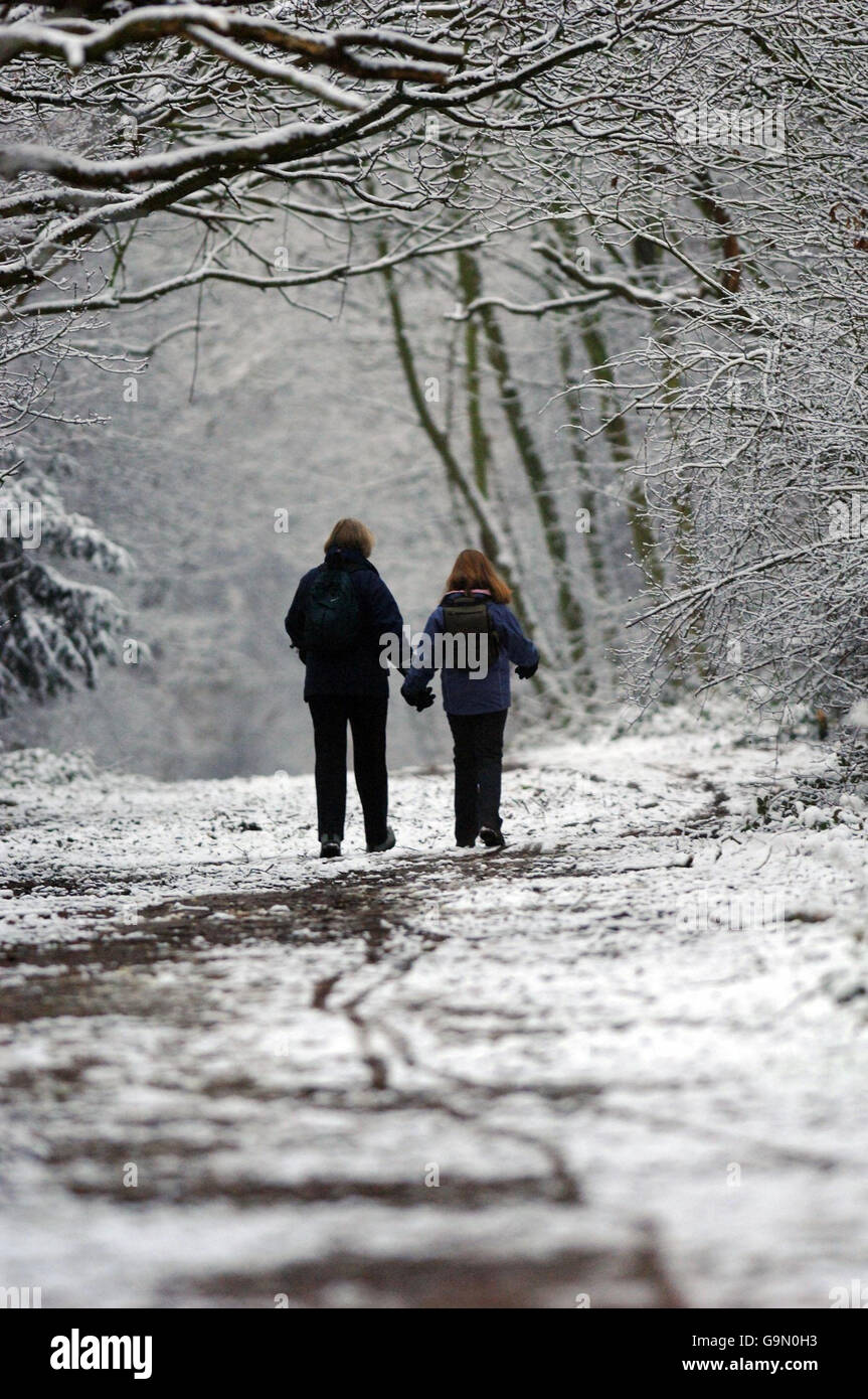 Una madre e una figlia in viaggio a scuola godersi la neve a Wanstead, a nord-est di Londra questa mattina. Foto Stock