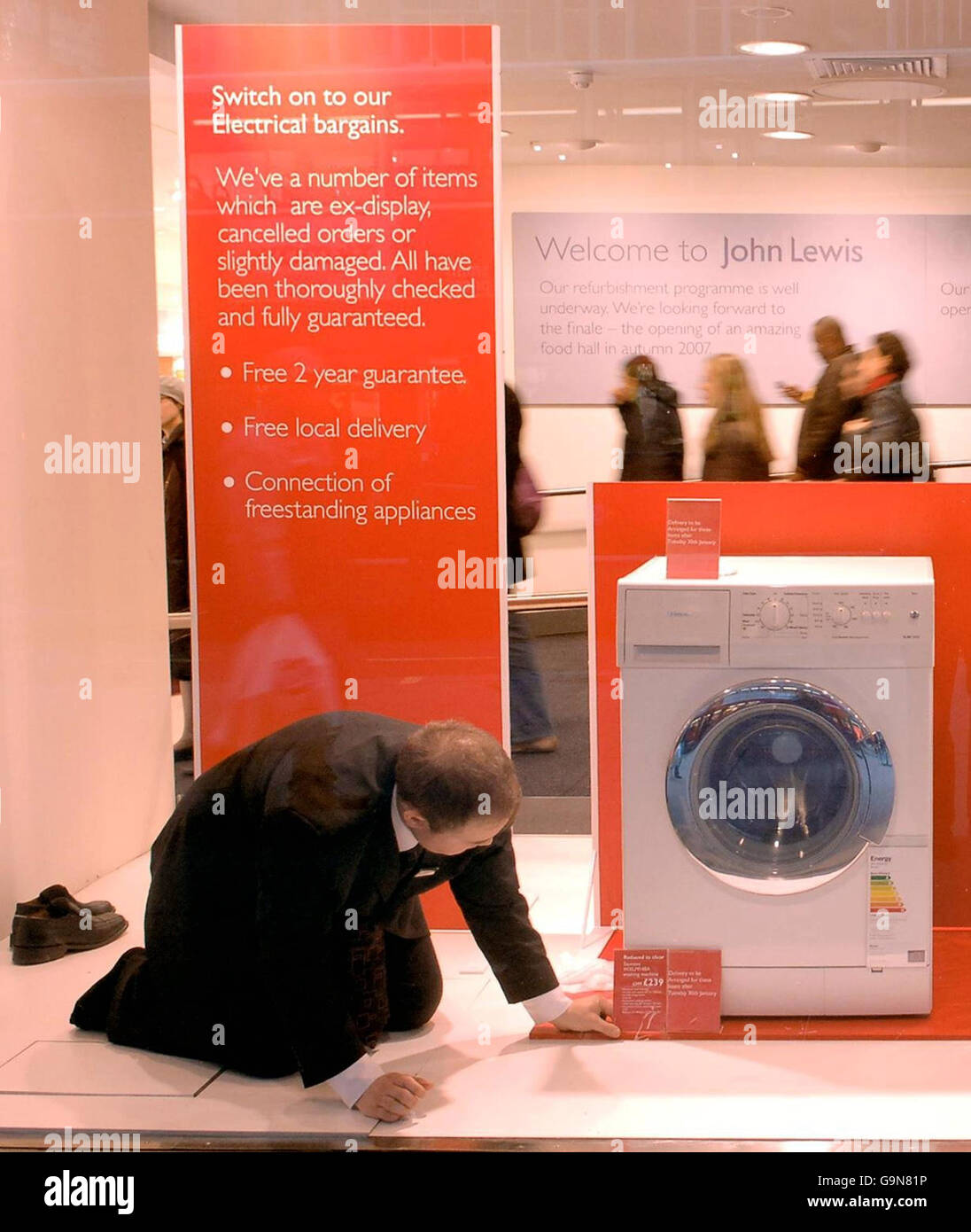 Il personale del grande magazzino John Lewis di Oxford Street di Londra finisce la vetrina, mentre i rivenditori si rinforzano per una giornata impegnativa mentre i cacciatori di occasioni gareggiano per acquistare i migliori articoli delle vendite post-natalizie. Foto Stock