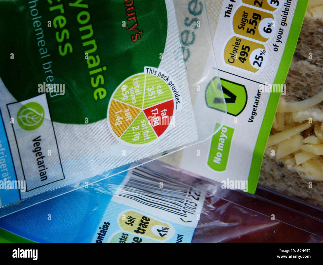 L'etichetta del sistema di semafori di Sainsbury (a sinistra) e l'etichetta dei valori percentuali di Tesco, che sono esempi di un'etichettatura contrastante dei nuovi prodotti alimentari nei supermercati, che mostra ai consumatori quanto il cibo sia sano contenuto nella confezione. Foto Stock