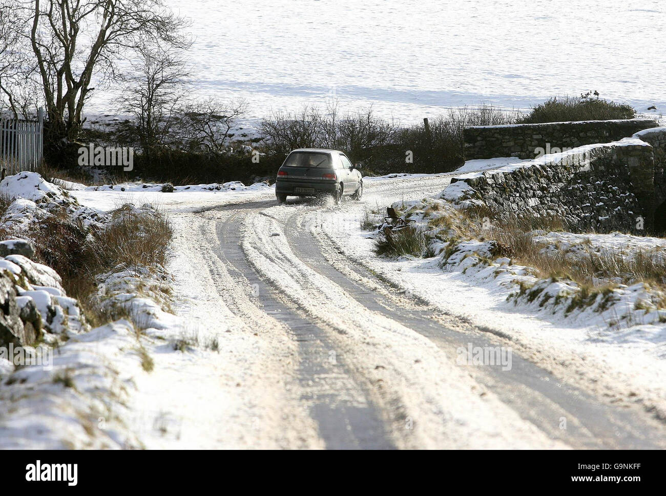 foto. Un'auto si fa strada lungo una strada innevata a Manor Kildare, sulle colline sopra Dublino. Foto Stock