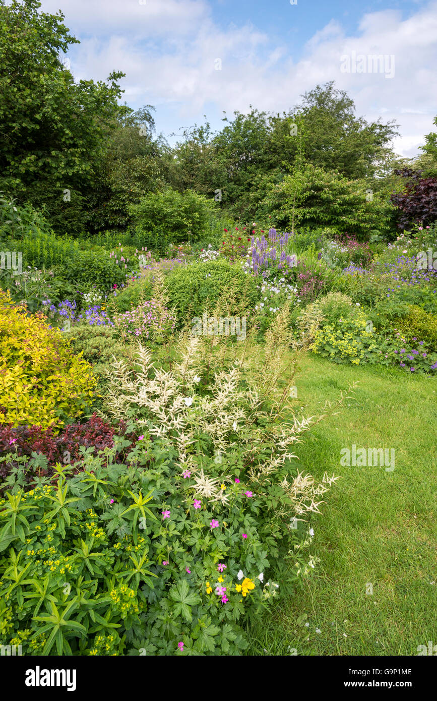 Bella English Country Garden a metà estate. Un abbondanza di piantando mescolato tra cui vari arbusti e piante perenni. Foto Stock