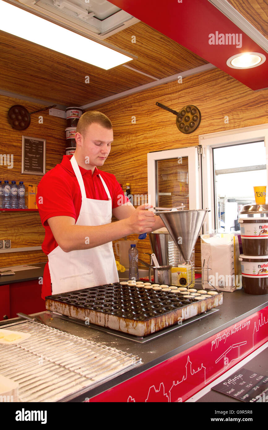 L'uomo facendo Poffertjes, tipici piccoli pancake, sull'Albert Cuypmarket nel centro di Amsterdam, Paesi Bassi nella primavera. Foto Stock