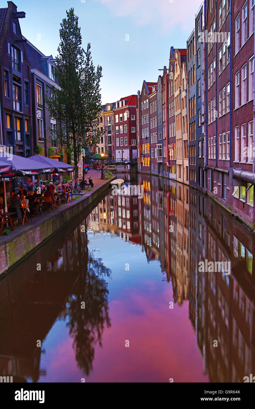 Case e ristoranti su Oudezijds Achterburgwal canal al tramonto in Amsterdam, Olanda Foto Stock