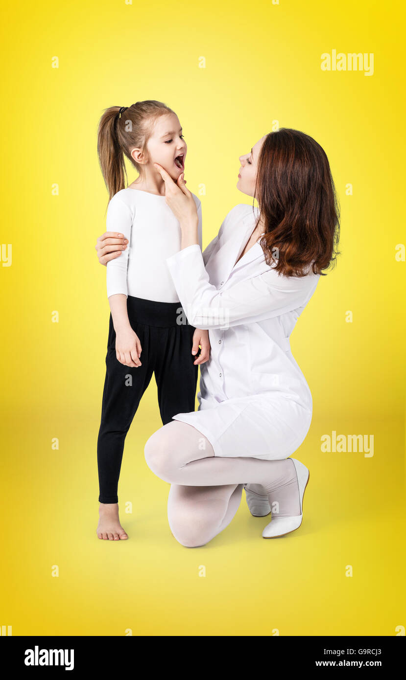 Medico di esaminare la gola della bambina Foto Stock