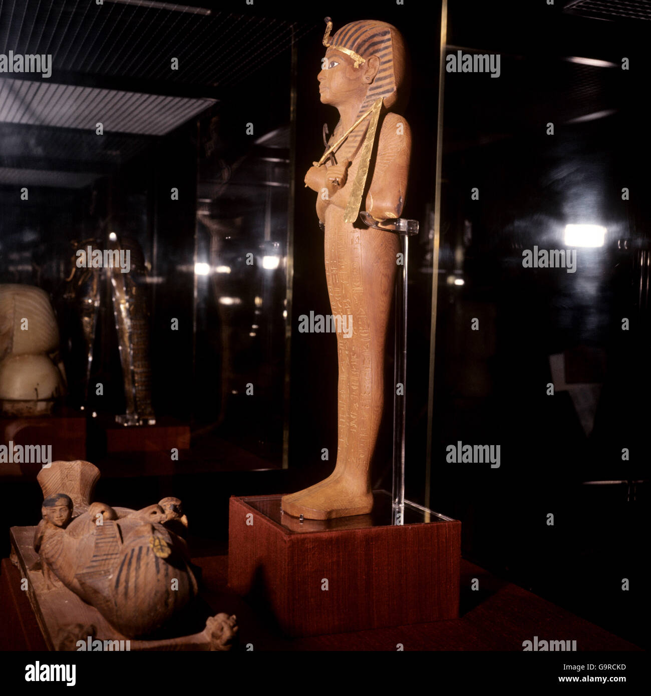 Ushabti figura del re Tutankhamon alla mostra del British Museum. Scolpito in legno, l'aspetto ha la parte inferiore del corpo avvolta come una mummia. Sulla sua testa indossa il Nemes a strisce blu headdress, un accampamento reale. Nelle sue mani sono gli emblemi del Dio Osiride, un truffatore e un flagello Foto Stock