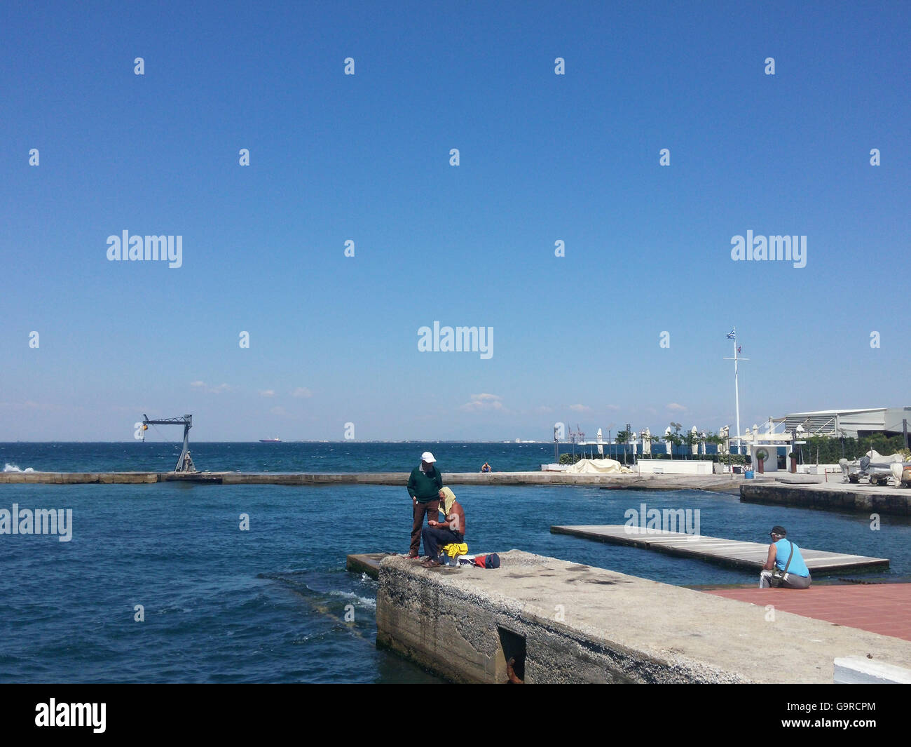La gente di pesca nel mare del nord della città greca di Salonicco Foto Stock