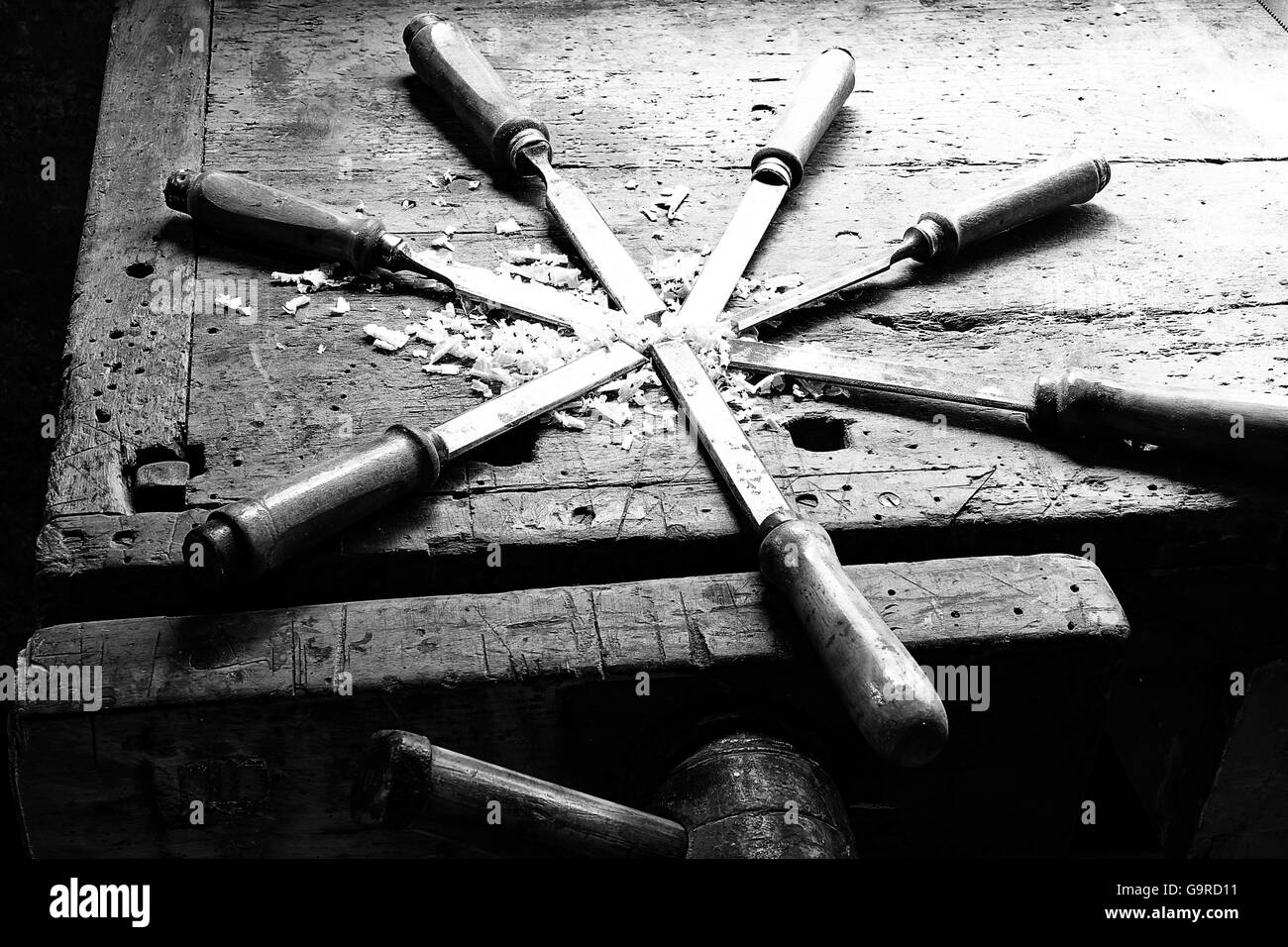 Serie di molti taglienti lame in acciaio molti scalpelli segatura e trucioli in un vecchio banco da lavoro Foto Stock