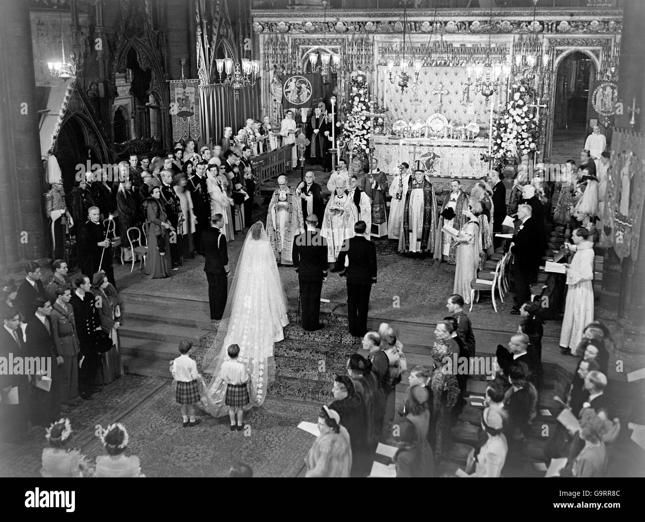 La scena ai gradini dell'altare durante la cerimonia nuziale reale nell'Abbazia di Westminster. H.M il re si trova a sinistra della sposa; a destra dello sposo c'è il bromo, le Marques di Milford Haven. Il treno della sposa è tenuto da due pagine del principe Guglielmo di Gloucester e del principe Michele di Kent. Foto Stock