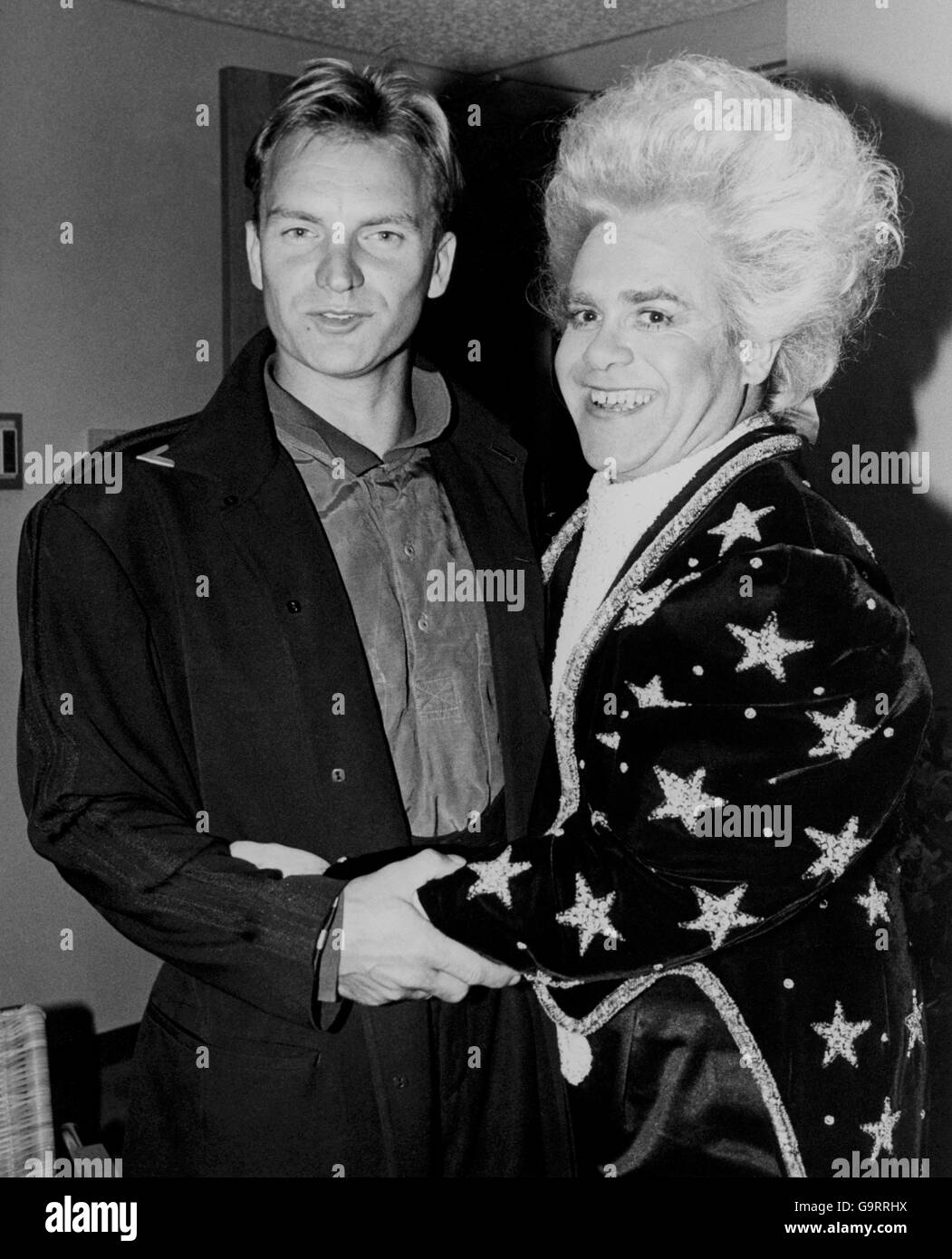 L'Amadeus Mozart cerca Elton John, abbracciato dal cantante Sting, al backstage party di Los Angeles alla fine del suo recente tour statunitense. Elton, che ha appena rilasciato un nuovo singolo dal titolo "Heartache all Over the World", sarà ospite di Esther Ranzten sulla TV Wogan Show di domani sera della BBC. Foto Stock