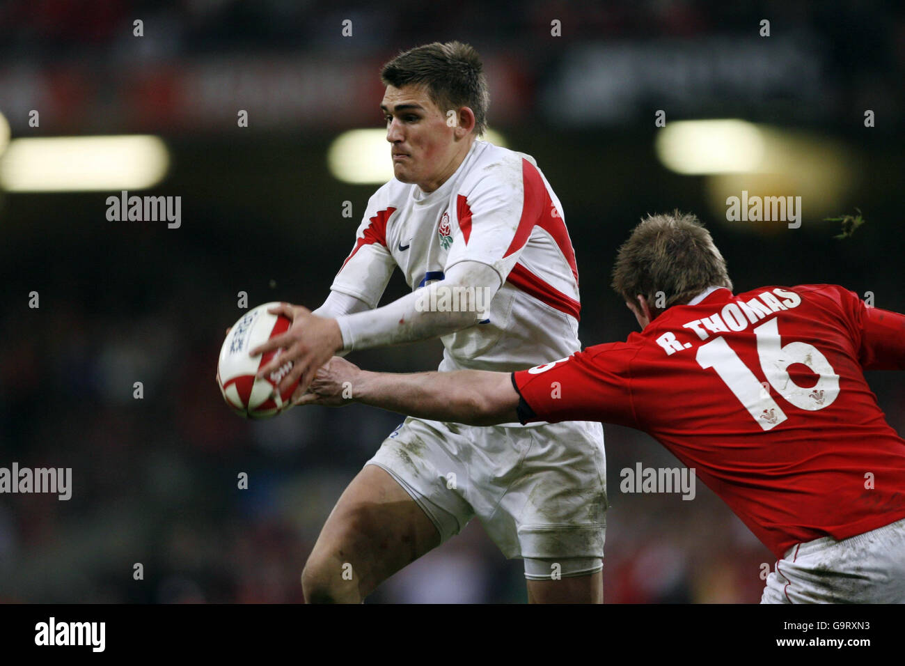 Il Toby Flood in Inghilterra viene affrontato dal Wales' Rhys Thomas (a destra) durante la partita RBS 6 Nations al Millennium Stadium di Cardiff. Foto Stock