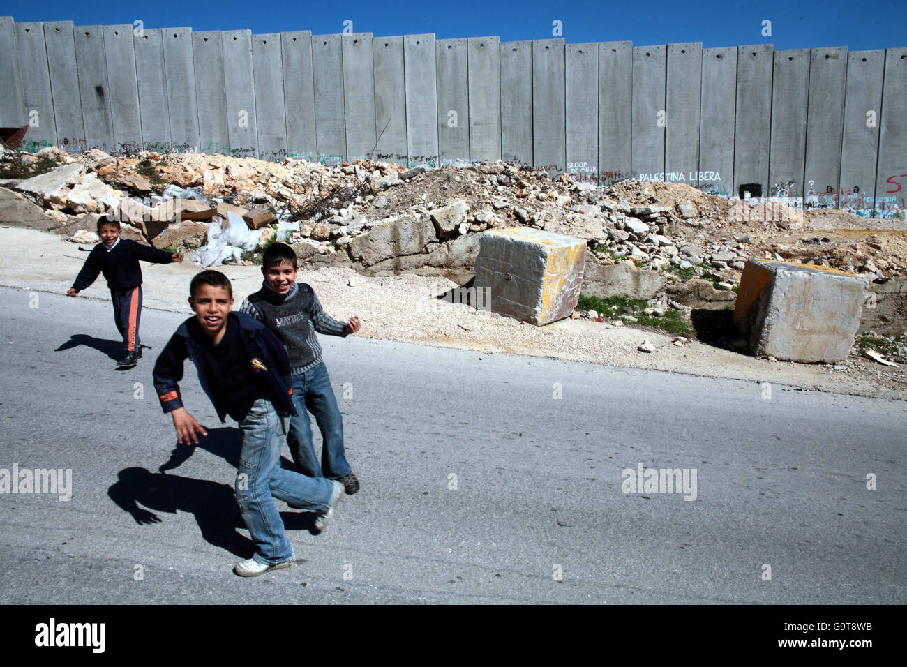 I bambini giocano vicino alla barriera della Cisgiordania israeliana a Gerusalemme. Foto Stock