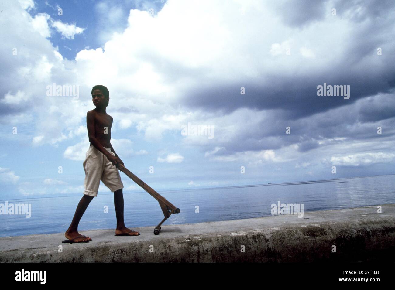 VIAGGI. RAGAZZO CON BARROW SUL MURO DEL MARE A L'AVANA, CUBA. Foto Stock