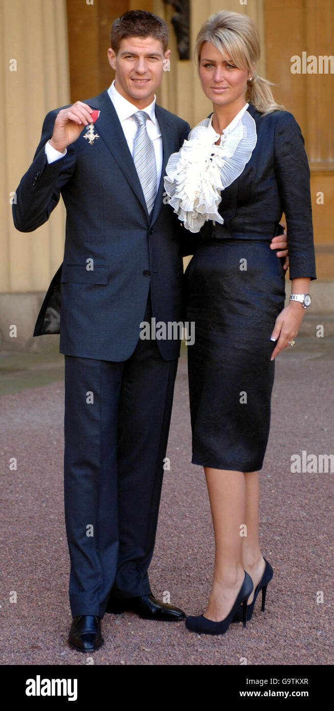 Il capitano di Liverpool Steven Gerrard si trova con il suo partner Alex Curran fuori Buckingham Palace, Londra, dopo aver raccolto un MBE dalla Regina Elisabetta II della Gran Bretagna Foto Stock