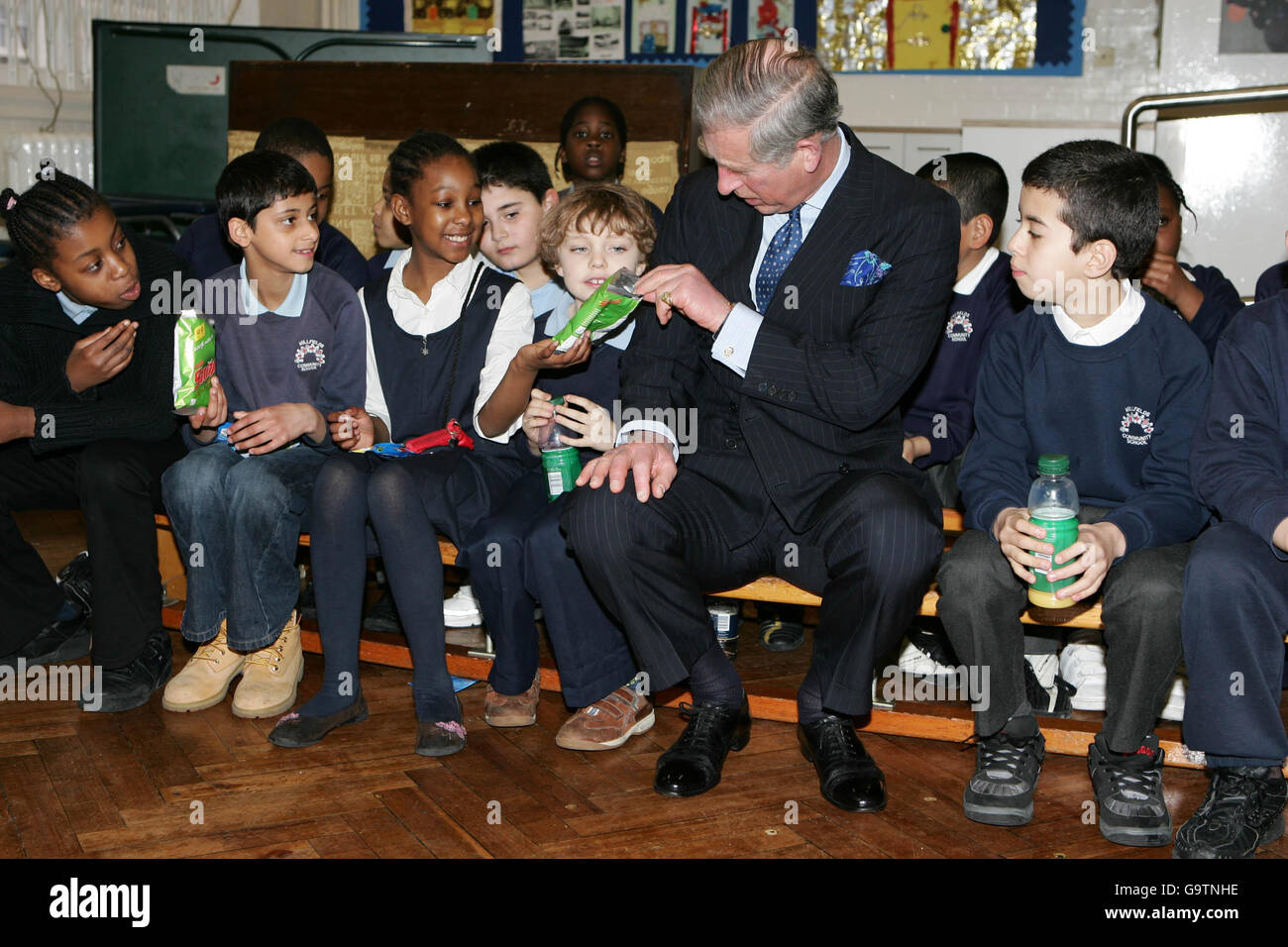Il Principe Carlo della Gran Bretagna, il Principe del Galles, viene offerto un croccante biologico di mela da Nuressa Khatun-Ahmed, membro del consiglio scolastico di nove anni, durante una visita alla Millfields Community School di Hackney, a est di Londra. Foto Stock