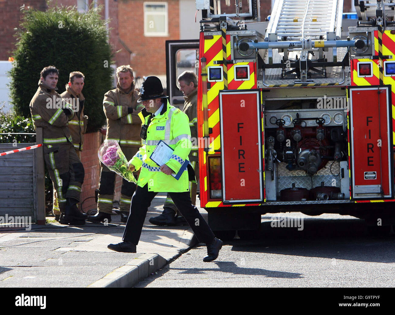 Un agente di polizia depone i fiori fuori di una casa a Lisle Road, South Shields, dove due ragazze sono morte oggi in un incendio di casa, la polizia ha detto. Foto Stock