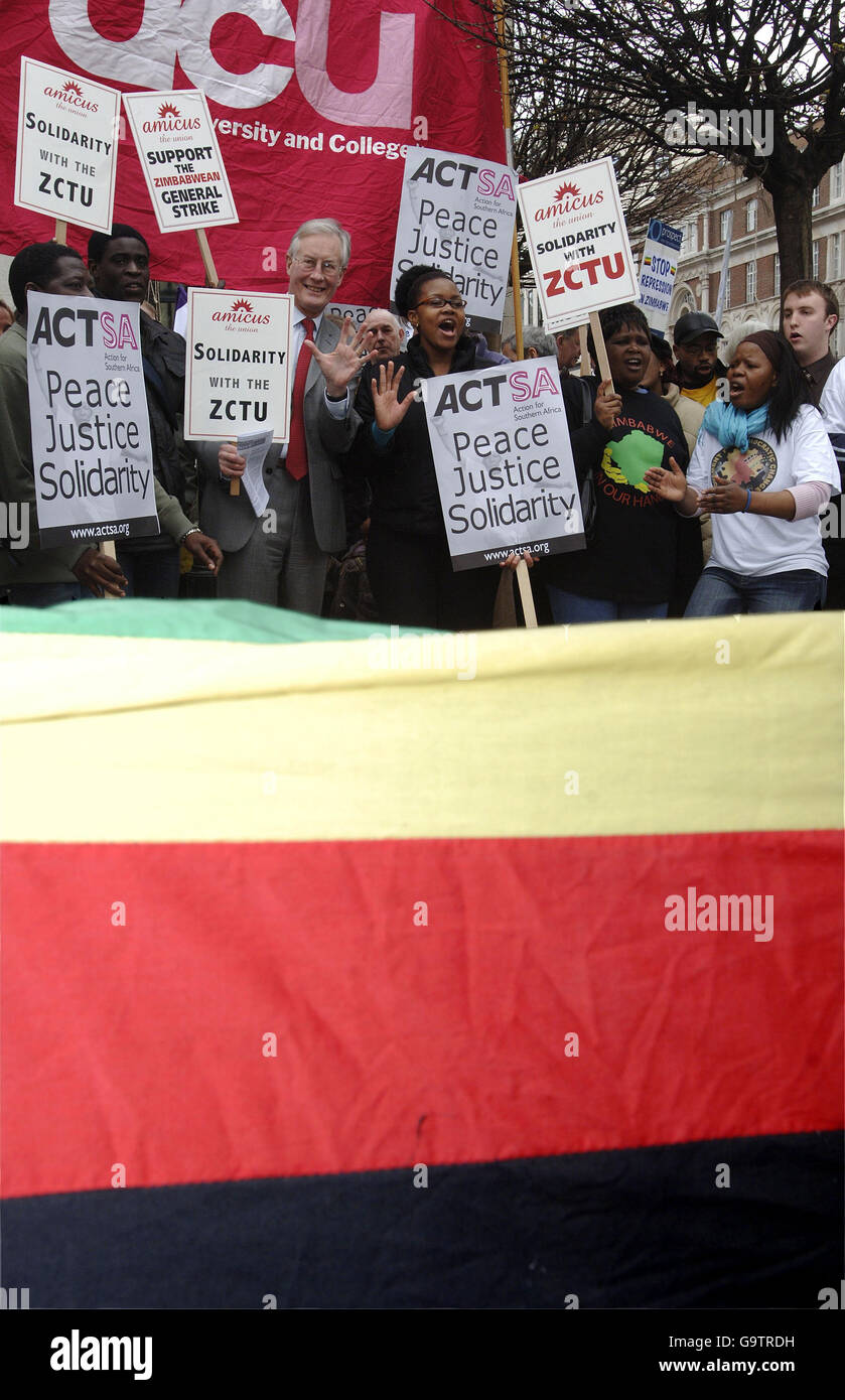 I dimostranti, tra cui l'ex ministro dell'ambiente Michael Meacher (centro - tuta grigia), si riuniscono all'esterno dell'ambasciata dello Zimbabwe nello Strand, nel centro di Londra. Foto Stock