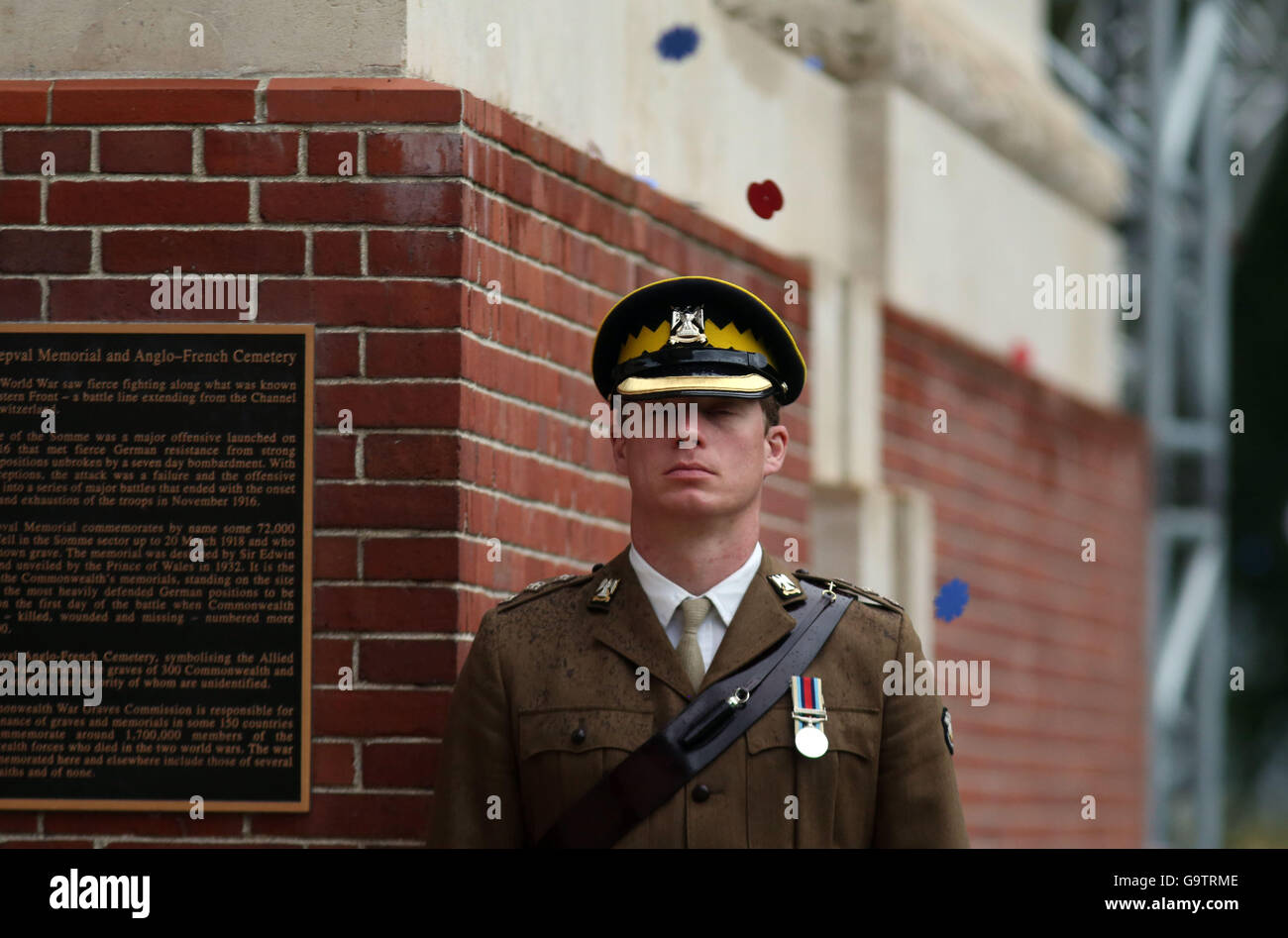 Papaveri cadere su un servizio militare di persona durante la commemorazione del centenario della Battaglia delle Somme presso la Commissione delle tombe di guerra del Commonwealth Thiepval Memorial in Thiepval, Francia, dove 70.000 British and Commonwealth soldati con noto alcun grave sono commemorati. Foto Stock