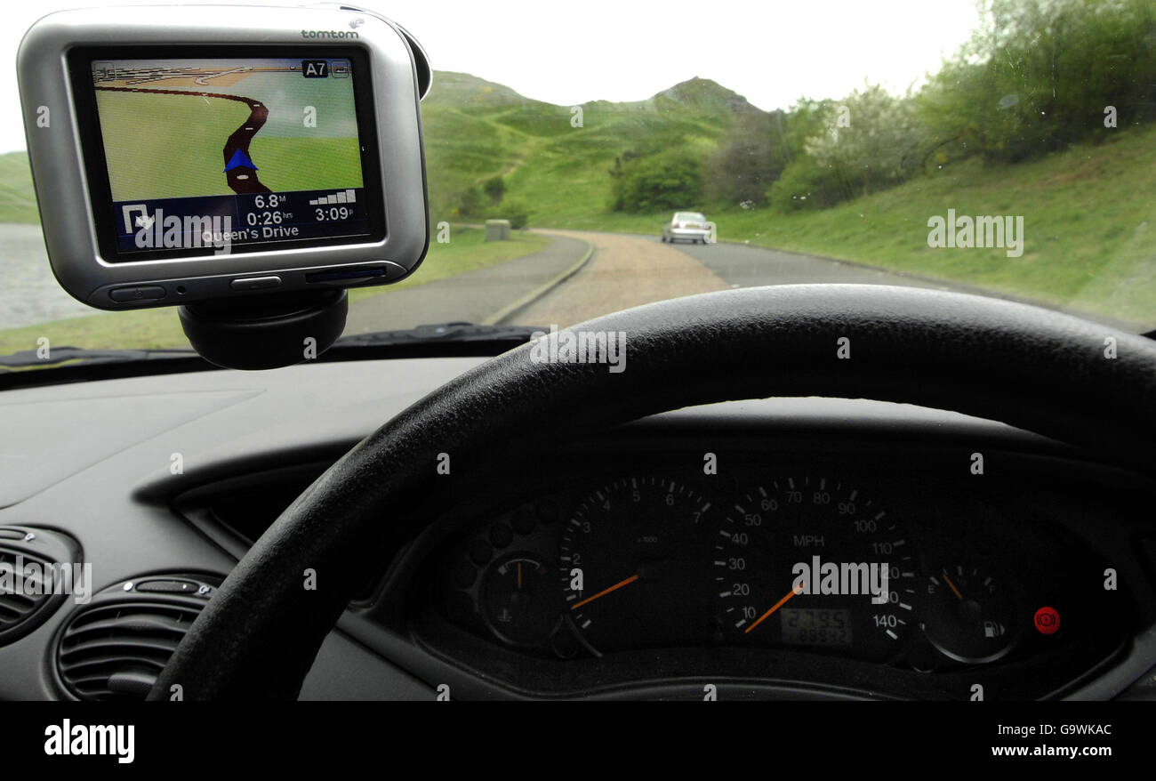 Scorta di gadget. Un sistema di navigazione satellitare Tom Tom è visto attaccato al parabrezza di un'auto. Foto Stock