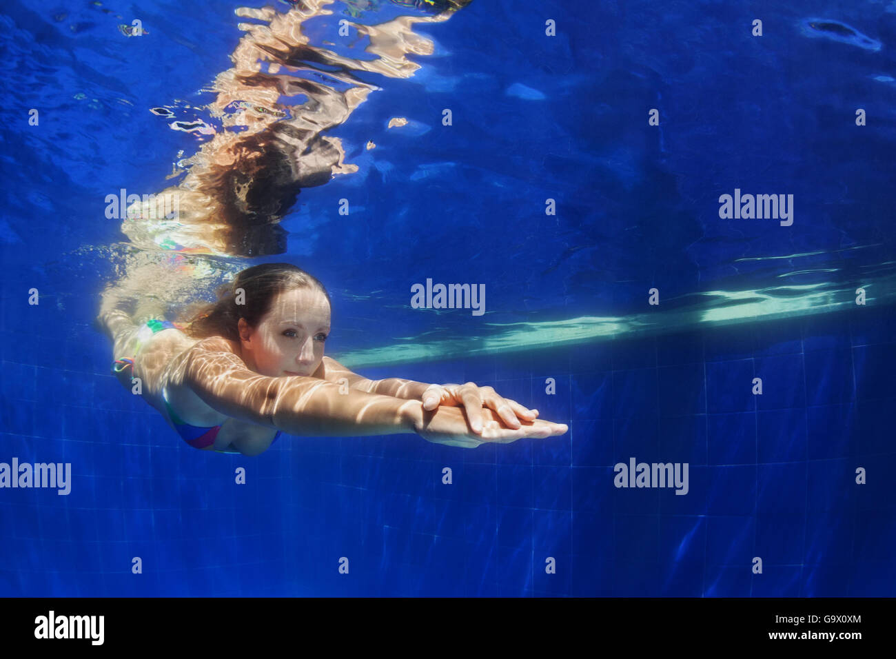 Bella giovane donna subacquea Immersioni con il divertimento dalla piscina al blu piscina. Un sano stile di vita attivo, persone acqua attività sportive Foto Stock