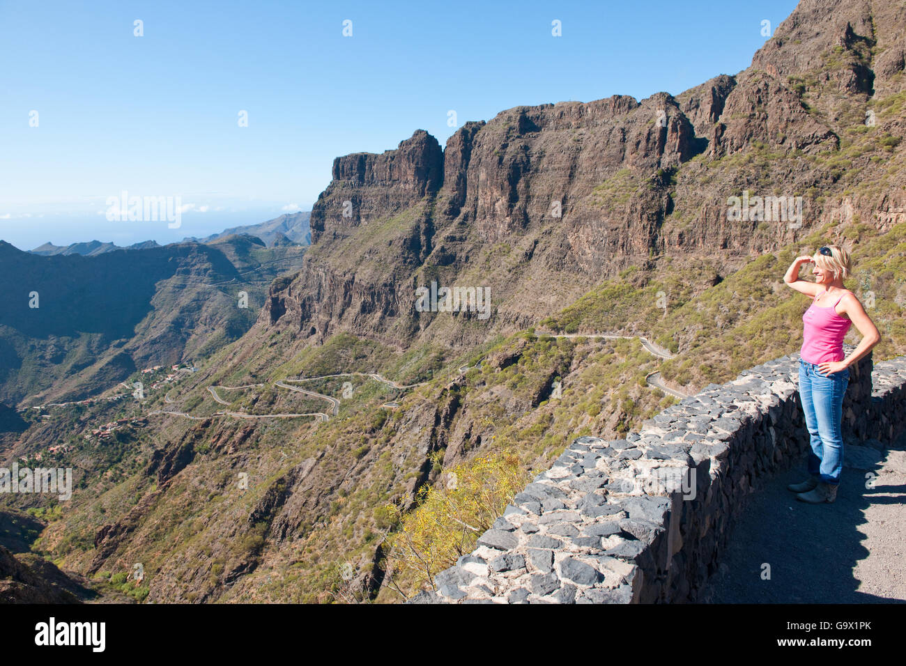 Donna che guarda la strada a serpentina in Valle Masca, curve Teneriffa, Spagna, Europa Foto Stock