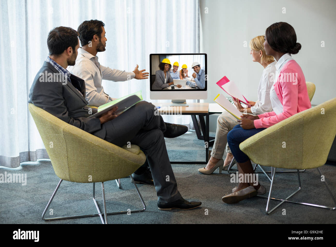 La gente di affari che guarda uno schermo durante una conferenza video Foto Stock