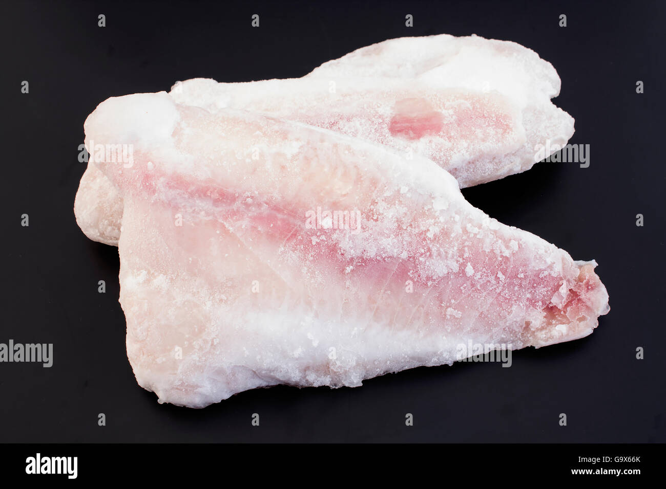 Congelati di filetti di pesce gatto su sfondo nero Foto Stock