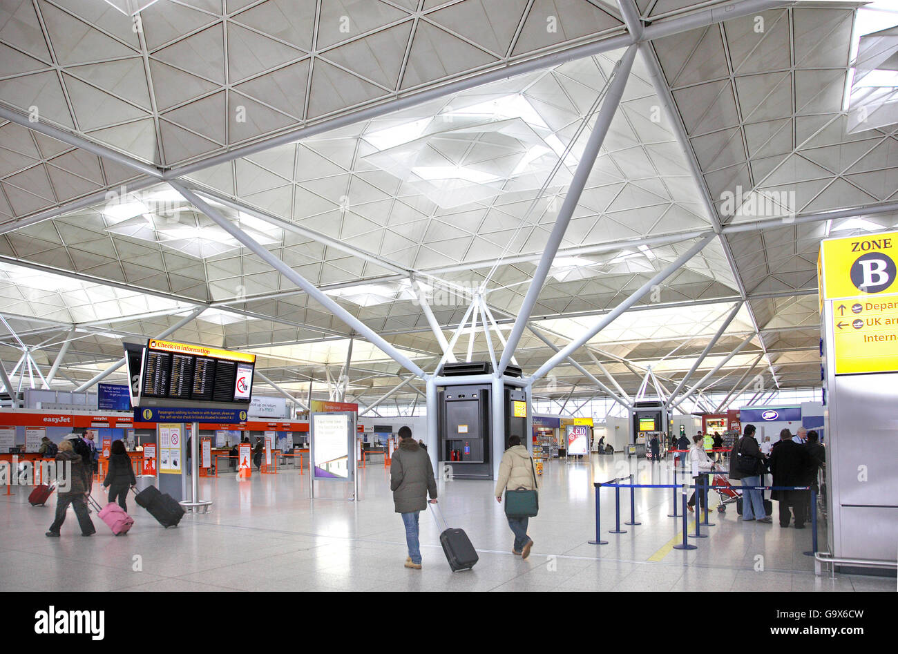 Interno dell'edificio del terminal principale a Londra Stanstead Airport. Mostra i passeggeri, schede di partenza etc Foto Stock