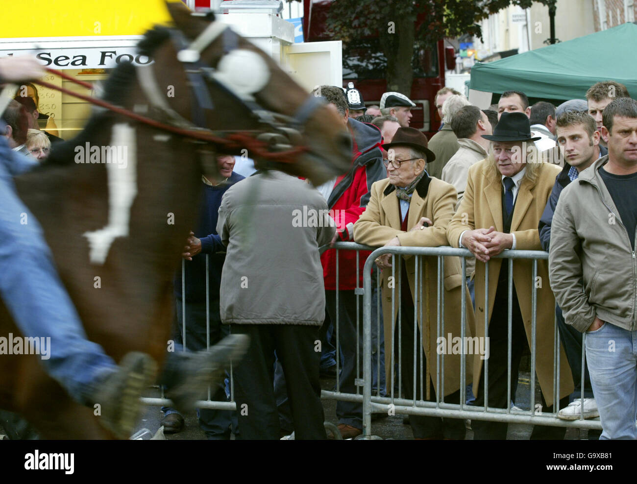 Gli uomini guardano i cavalli all'annuale Wickham Horse Fayre vicino a Fareham, Hampshire. Ogni anno, diverse centinaia di persone, per lo più ROM zingari discendono sul tranquillo villaggio per commerciare i loro cavalli in una tradizione che risale al 13 ° secolo, quando è stato concesso un charter reale. Foto Stock