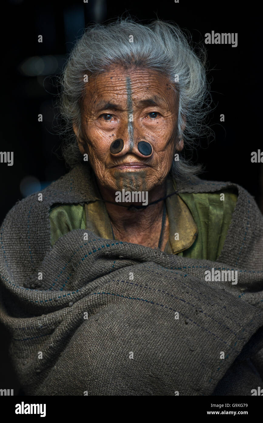 Apatani donna donna con tatuaggi facciali e canna tradizionale naso tappi / Yapin Hulo realizzato per farli sembrare poco attraente per i maschi dalle altre tribù. Queste modifiche del viso sono ora fuorilegge. Tribù Apatani, Ziro Valle, foothills dell'Himalaya, Arunachal Pradesh.nord est dell India, novembre 2014. Foto Stock