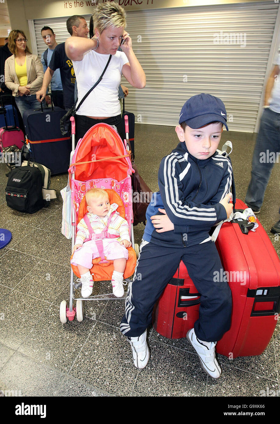 Layla Nugent, la figlia di nove mesi Katie e il figlio di sette anni del partner Jordan si preparano a effettuare il check-in per un volo diretto a Sharm el Sheikh all'aeroporto di Newcastle. Foto Stock
