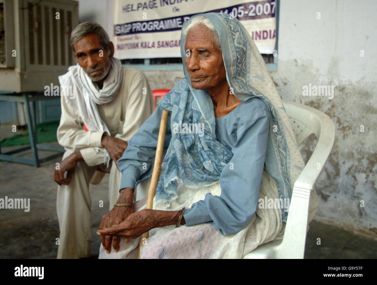 I beneficiari anziani del programma "Sponsor a Grandgenitore" di Aiuto attendono la consegna delle loro razioni, presso il centro Nav Yuvak Kala Sangam di Rohtak, India settentrionale, dove vanno mensilmente per ricevere un pacchetto di cibo e aiuti. Foto Stock