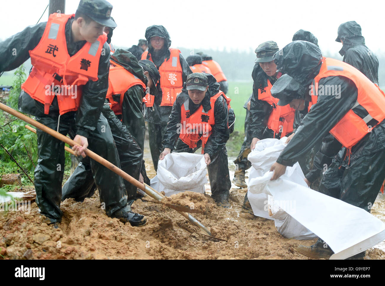 Anqing, cinese della provincia di Anhui. 2 Luglio, 2016. Poliziotti armati preparare dei sacchi di sabbia per il salvataggio nel villaggio Mingfeng della contea di Huaining nella città di Anqing, est cinese della provincia di Anhui, 2 luglio 2016. A causa di forti precipitazioni, i soccorritori sono stati inviati per evacuare i residenti intrappolati in alluvioni in Anqing Cittã sabato. Credito: Guo Chen/Xinhua/Alamy Live News Foto Stock