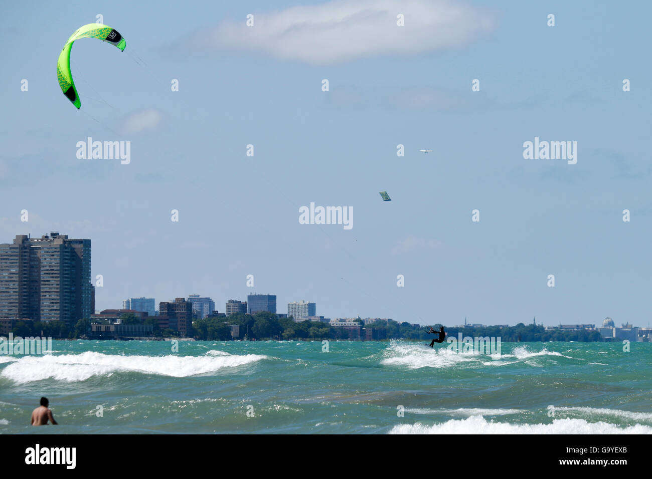 Chicago, Stati Uniti d'America. Il 1 luglio 2016. Un kite boarder cavalca il surf a Montrose Beach sulla città e sul suo lato nord. Forti venti di nord-est mantecato fino onde e generato correnti di rip sul Lago Michigan. Foto Stock