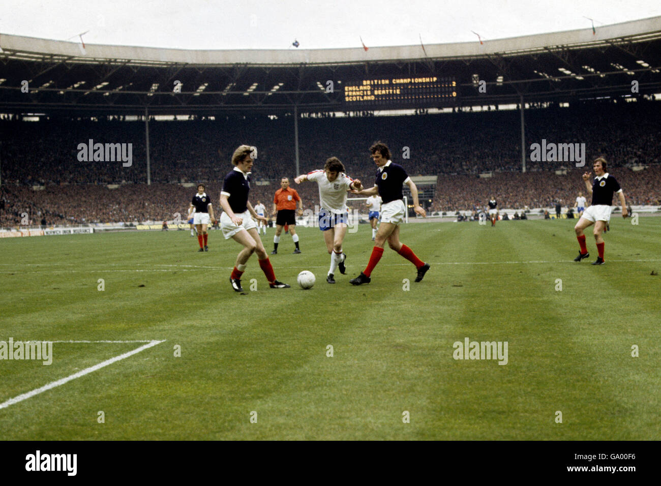 Calcio - Inghilterra / Scozia. Mike Channon, l'Inghilterra in avanti, cerca di attraversare Francis Munro e Gordon McQueen (a sinistra) della Scozia Foto Stock