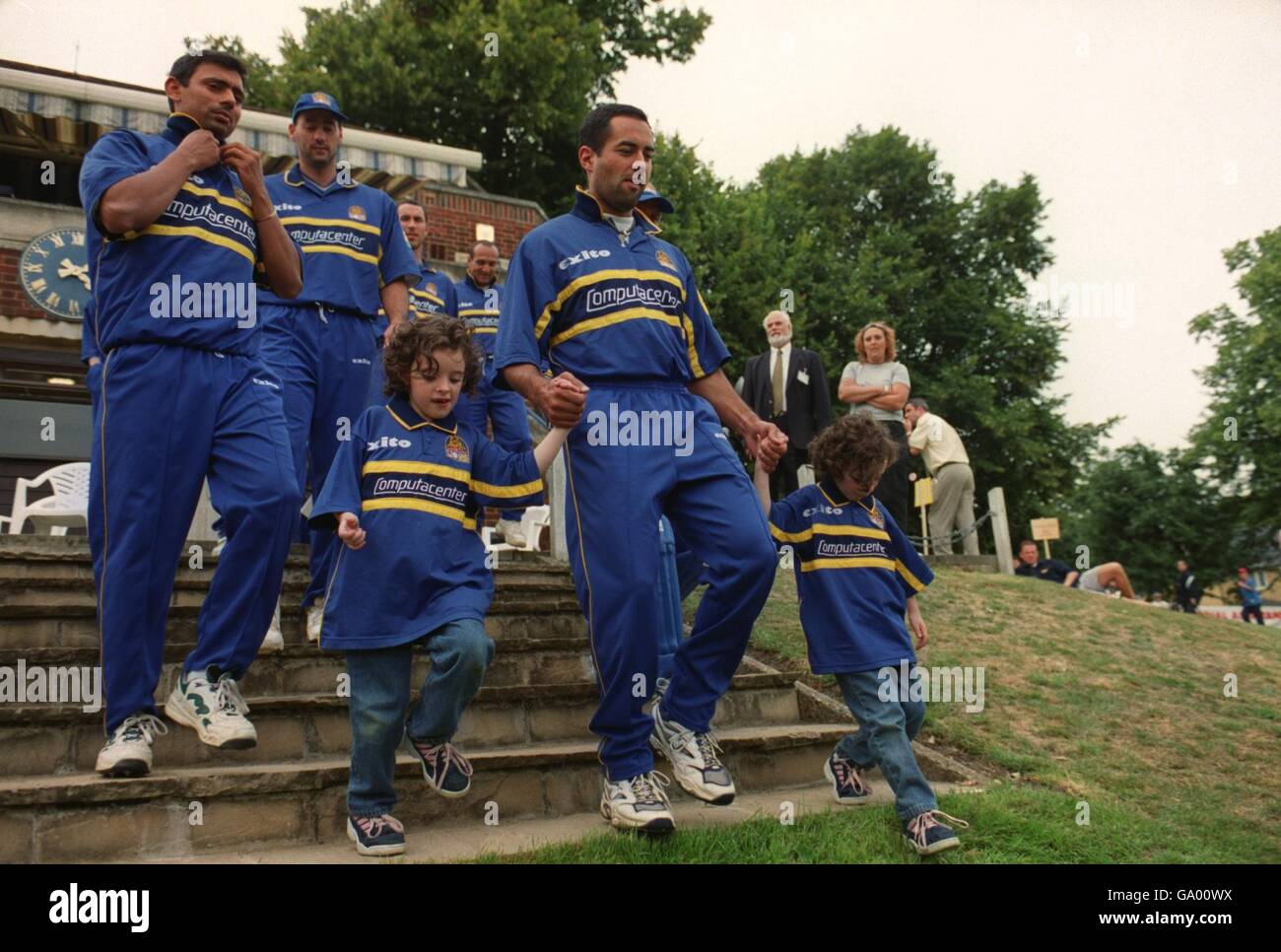 (L-R) Saqlain Mushtaq e Adam Hollioake dei Surrey Lions escono dal padiglione con mascotte gemelle Foto Stock