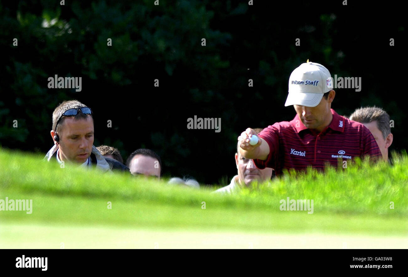 Padraig Harrington lascia cadere la palla dopo che il suo secondo colpo sul 1 ° foro finito in cima a uno zaino spettatore durante il secondo round del campionato BMW al Wentworth Golf Club, Virginia Water, Surrey. Foto Stock