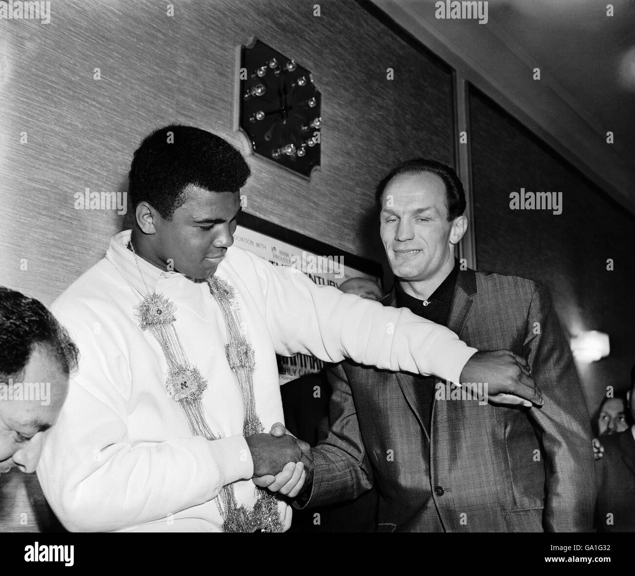 (L-R) il campione del mondo dei pesi massimi Muhammad Ali lancia una croce di sinistra amichevole allo sfidante Henry Cooper mentre si incontrano nel Piccadilly Hotel, Londra, per pubblicizzare la loro lotta Foto Stock