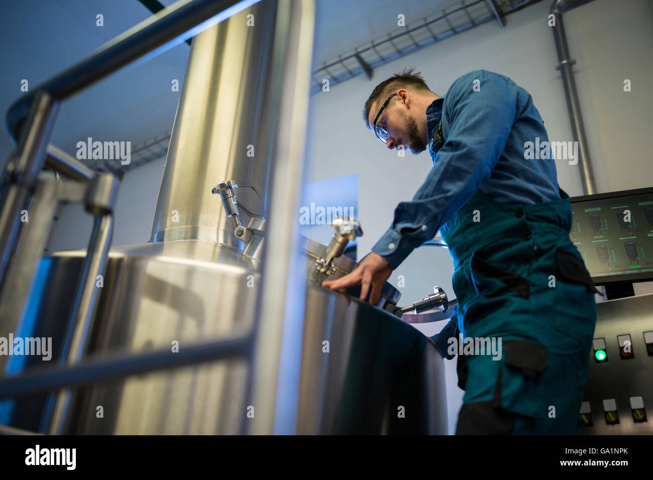 Lavoratore di manutenzione a lavorare presso la fabbrica di birra Foto Stock