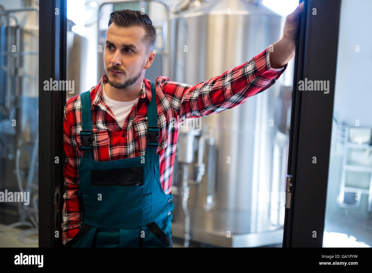 Il birraio in piedi presso la fabbrica di birra Foto Stock